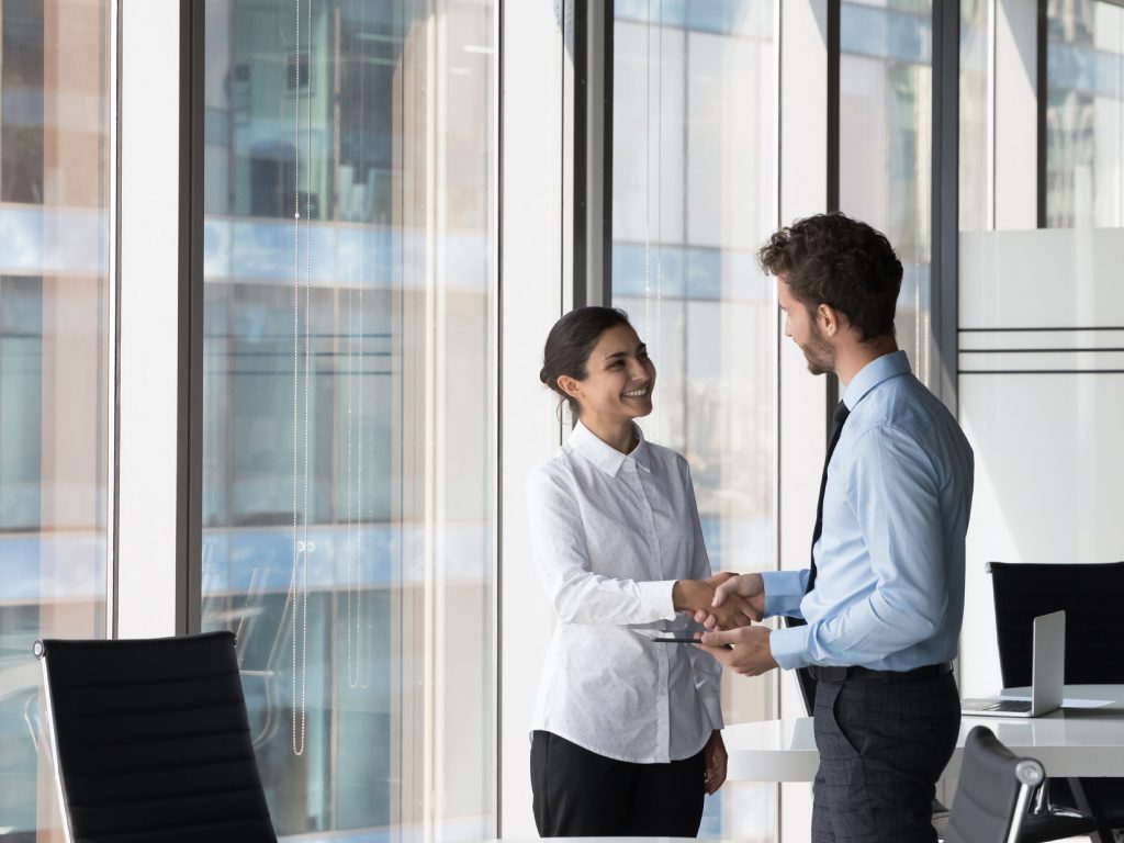 Multi ethnic client and manager make deal, handshaking, express respect