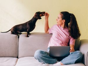 Young Woman Enjoying Time with Her Dachshund at Home.